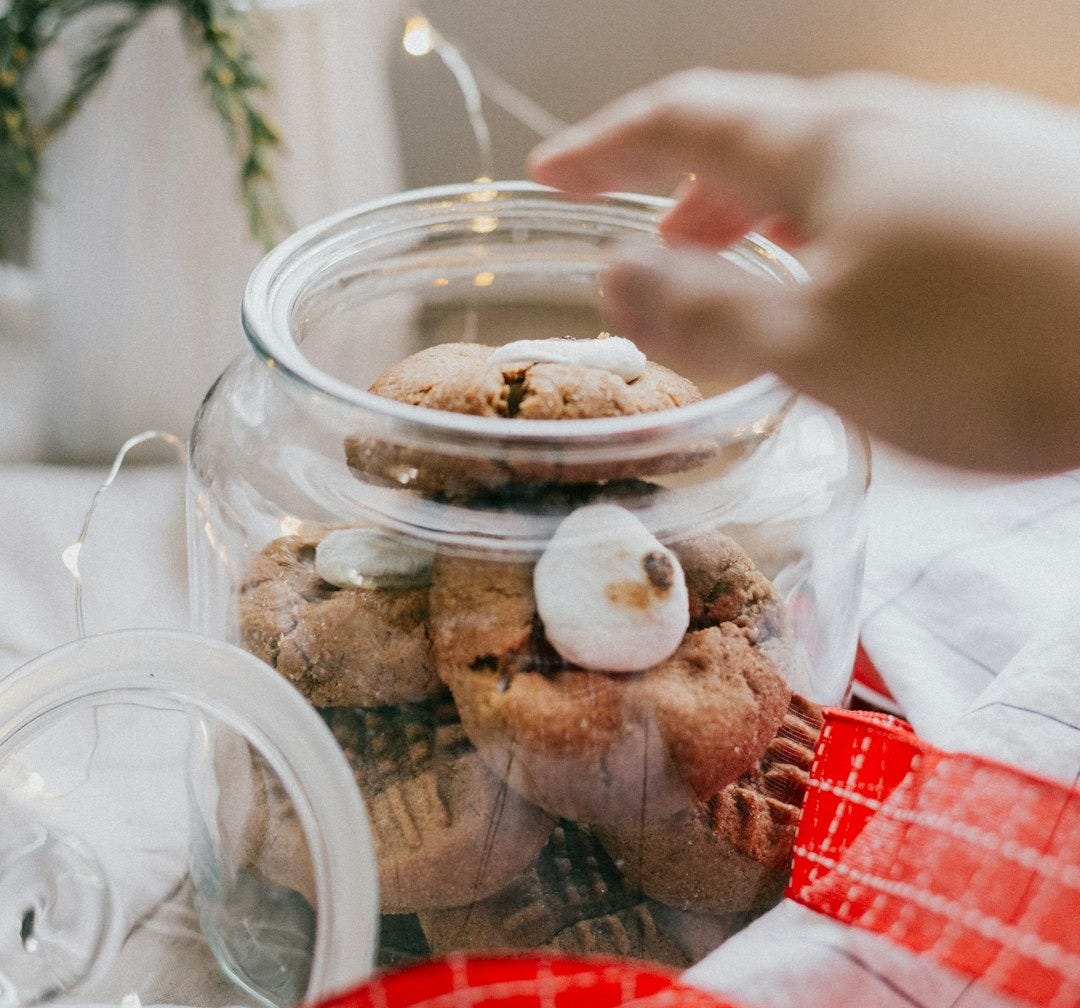 person holding clear glass jar with food person holding clear glass jar with food