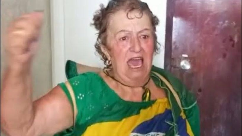 Foto da golpista "Fátima" de Tubarão/SC vestida com uma blusa regata fom uma imagem da bandeira do Brasil, durante os ataques à Praça dos Três Poderes, a mulher parece gritar algo.