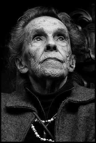 A black and white photograph of a very old Leonora Carrington, with lots and lots of wrinkles on her face.