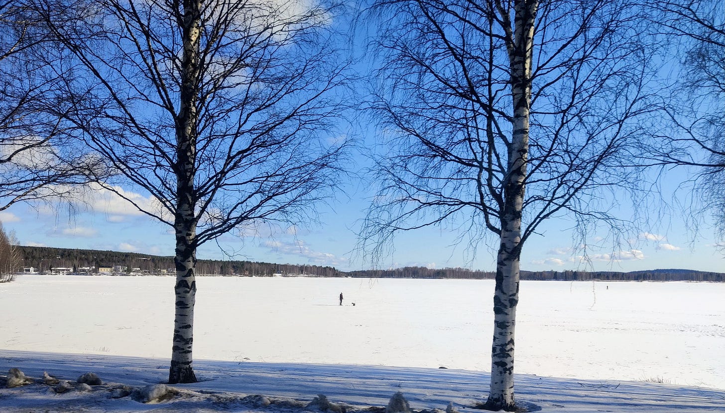 A man ice fishing on a frozen lake in Rovaniemi