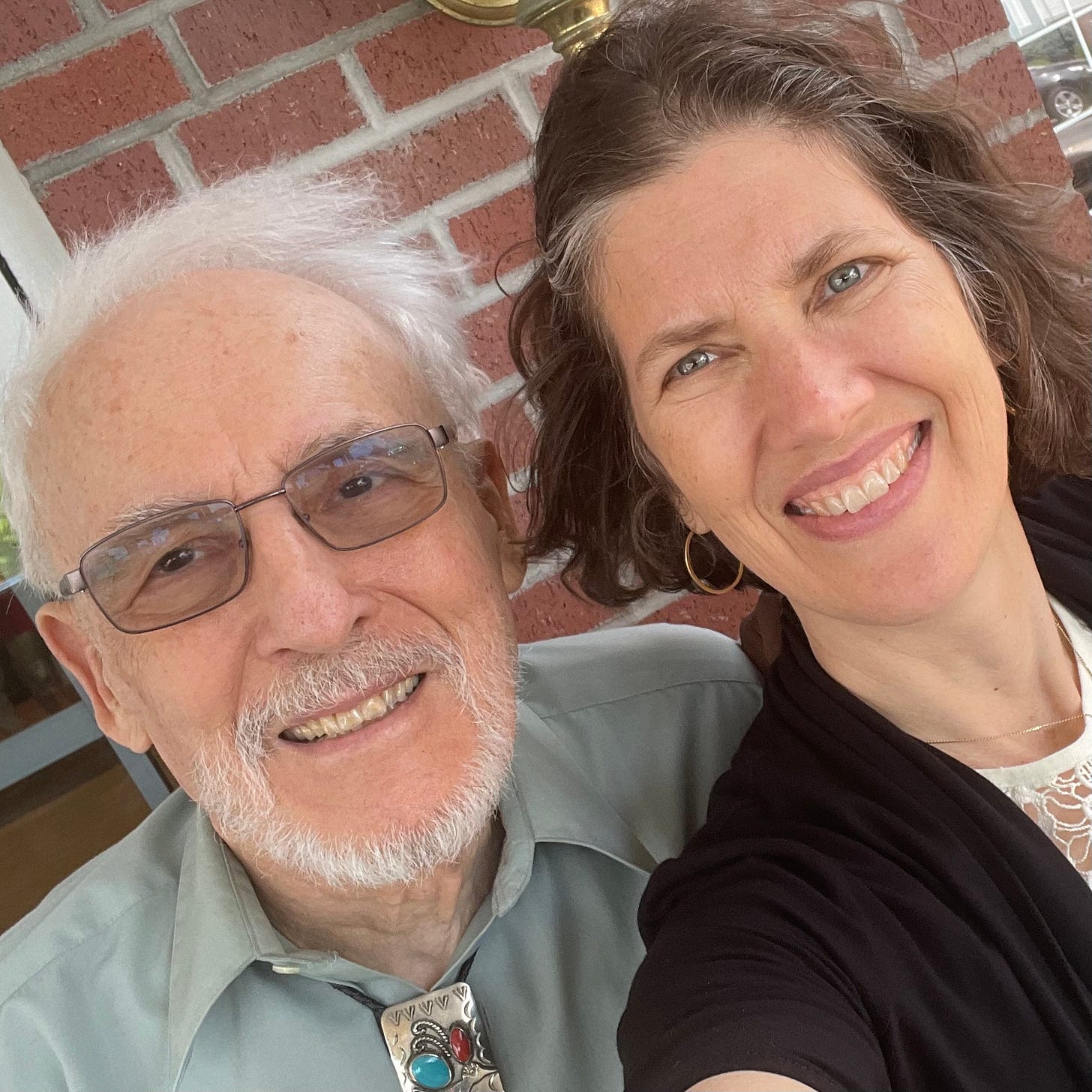 A white-haired man and graying woman smile for the camera