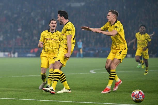 Dortmund's German defender Mats Hummels celebtrates with teammates after scoring his teams first goal during the UEFA Champions League semi-final...