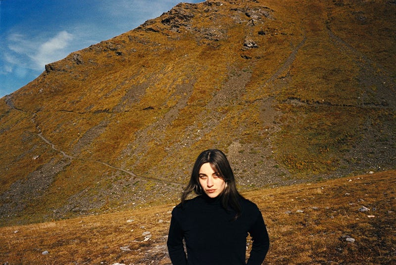 Kali Malone standing in front of a large hill