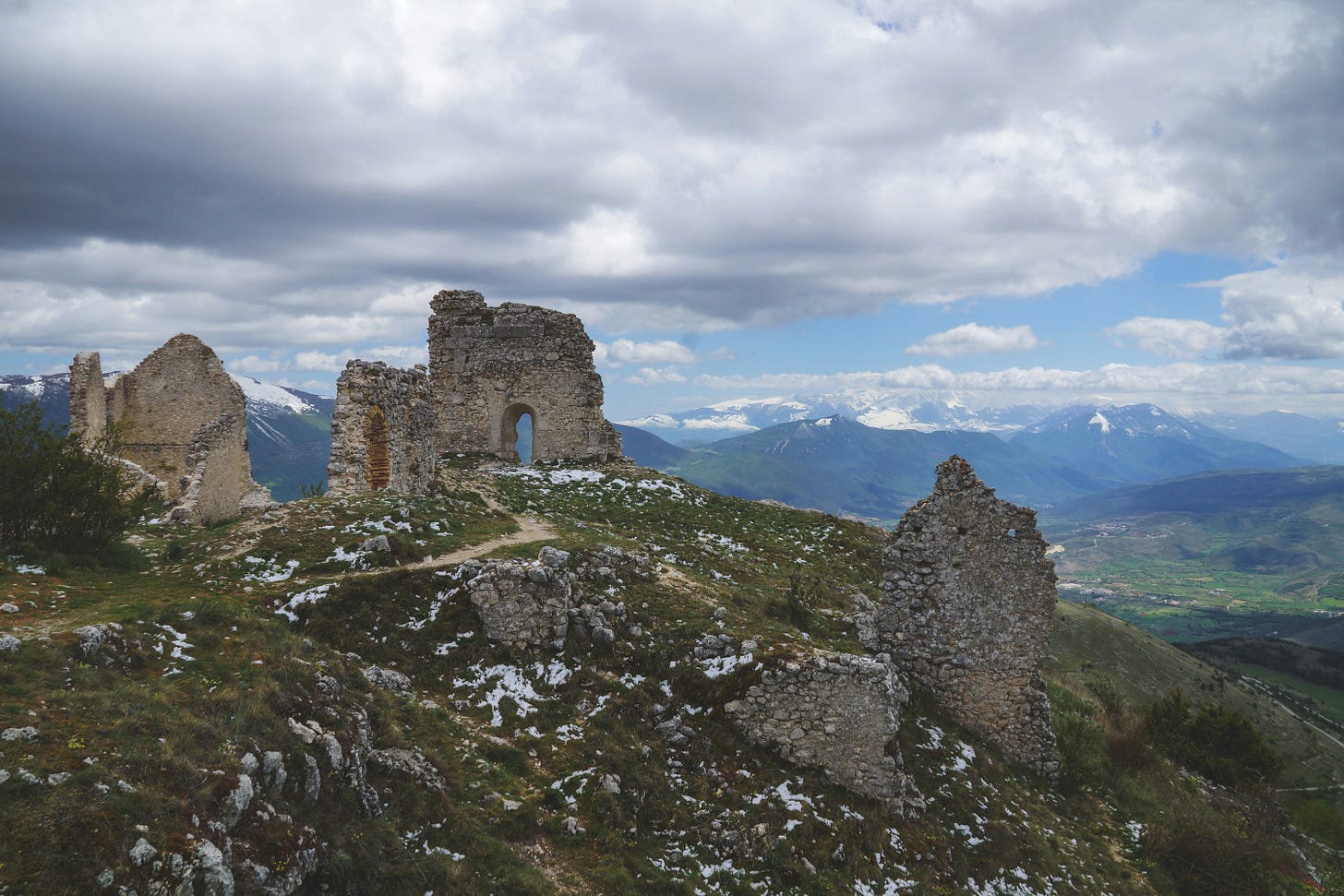 Stone ruins sit atop a mountain.