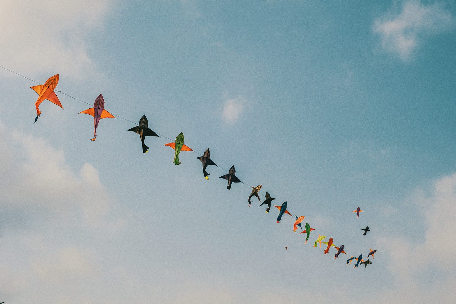 A string of fish-shaped kites floating in the sky.