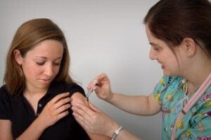 Nurse delivers covid vaccine to woman patient's arm