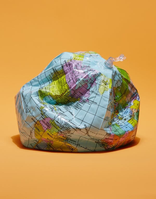 Foto di un pallone da spiaggia con la stampa di un globo terrestre parzialmente sgonfio.
