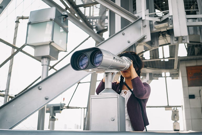 A woman looking through a large set of binoculars