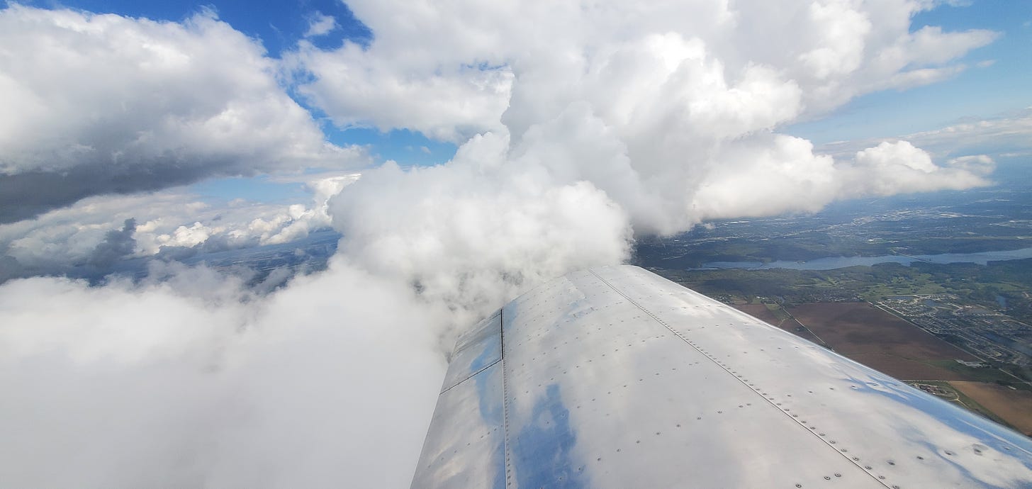 View of clouds and land from a small airplane