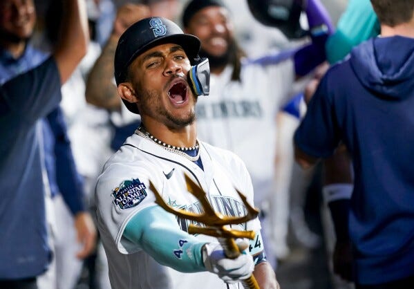 Seattle Mariners' Julio Rodriguez points a trident in the dugout as he celebrates a two-run home run to score J.P. Crawford against the Oakland Athletics during the fourth inning of a baseball game, Monday, Aug. 28, 2023, in Seattle. (AP Photo/Lindsey Wasson)