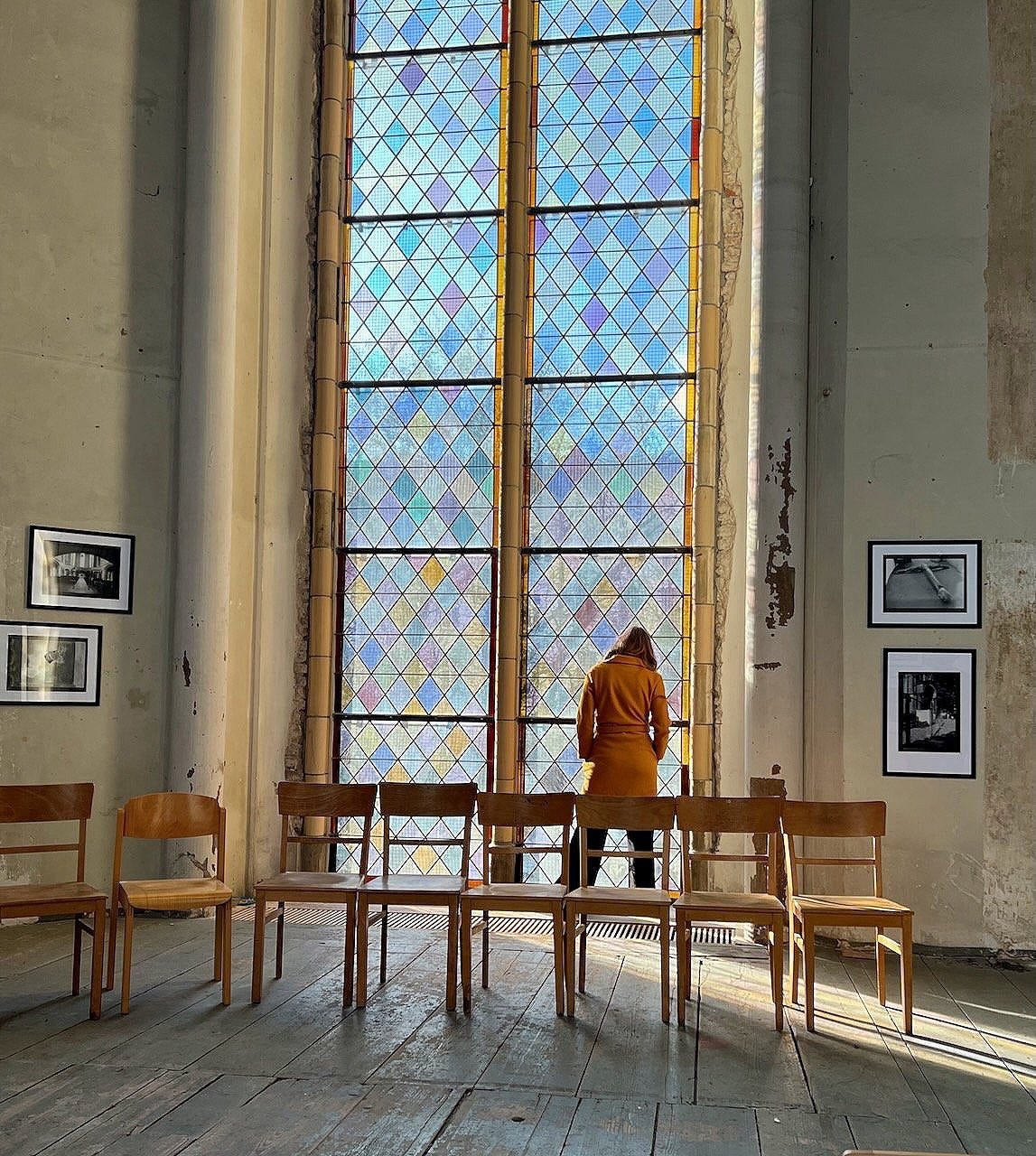 Woman meditating in-front of a church window.