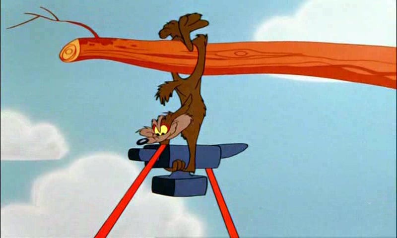 TV still from Looney Tunes. Wile E. Coyote dangles from a tree branch, about to drop an anvil.