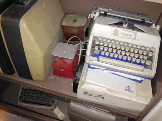 Photo of old typewriters and postal scales.