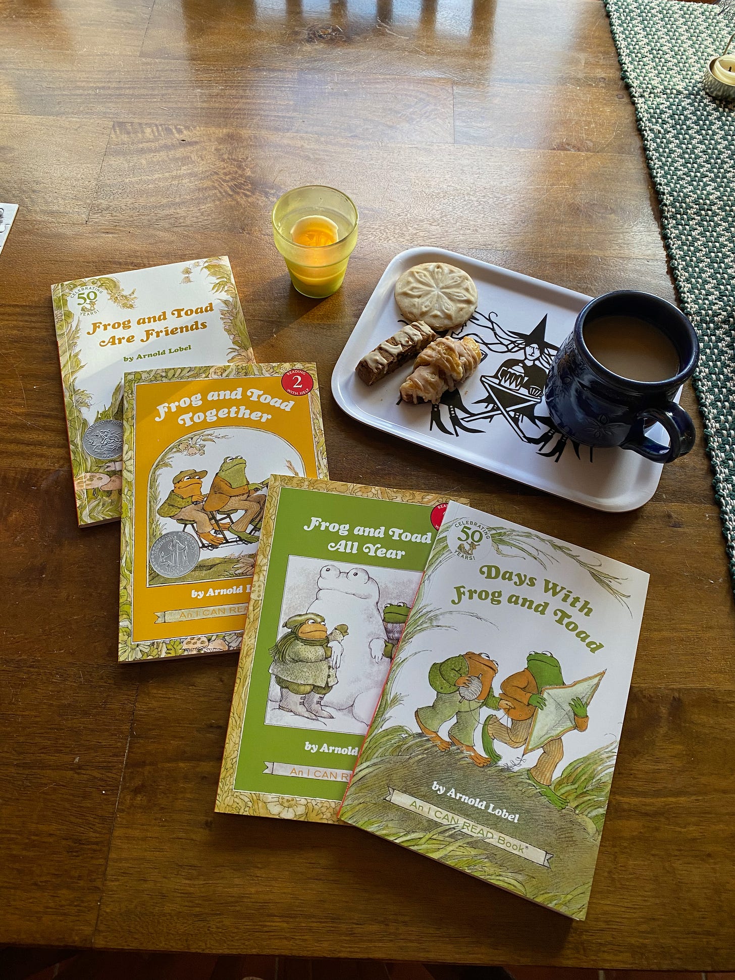 The four Frog and Toad books on a table next to tray with a mug of tea and several cookies.