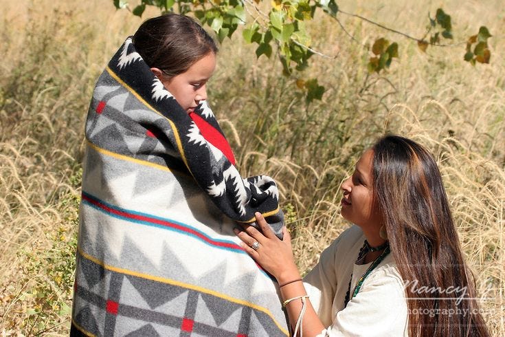 A Native American Sioux Indian mother wrapping an Indian blanket around her young child | Native ...