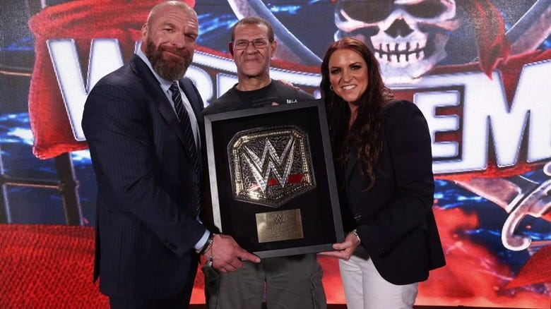 Vlad the Superfan pals around with Triple H and Stephanie McMahon