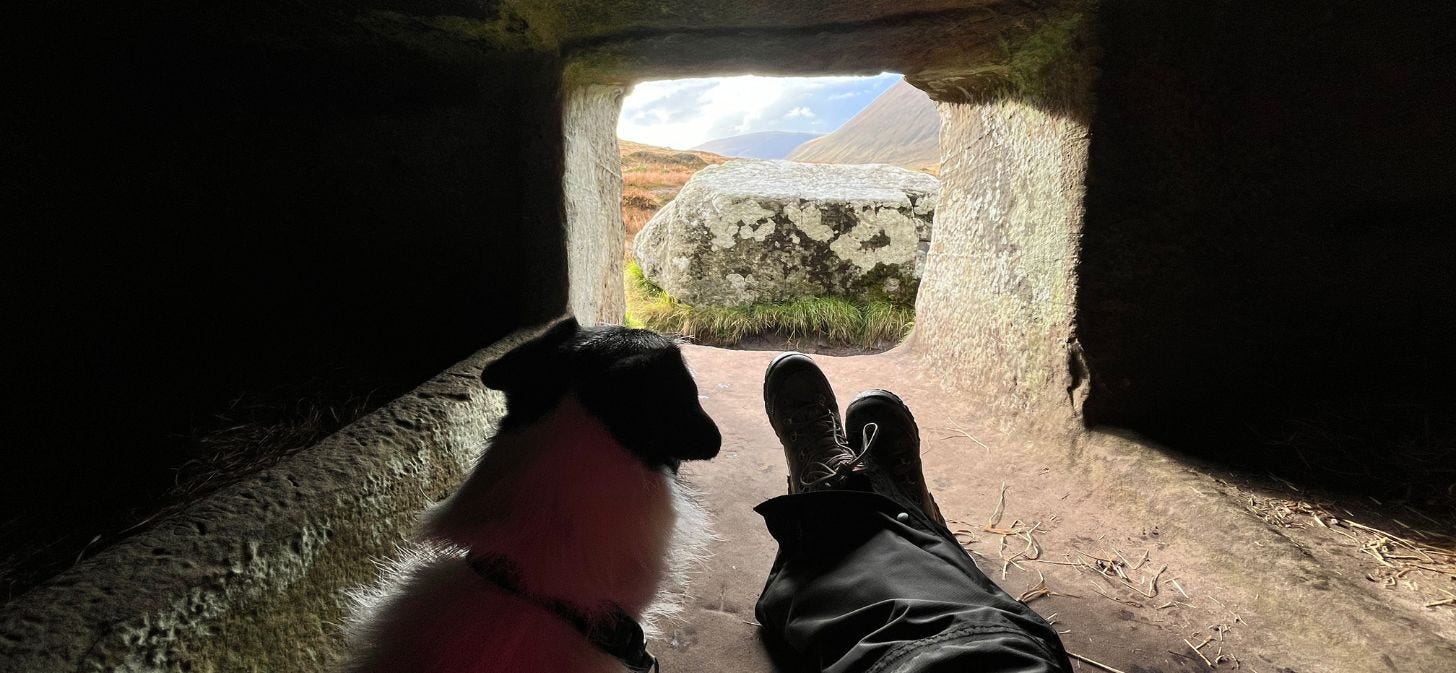 Image of Kiki & I in the narrow passage of Dwarfie Stane, looking out onto the hills. You can see Kiki's head & my legs