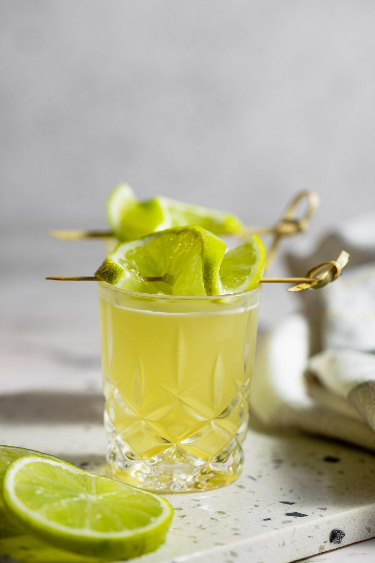 green tea shot garnished with lime slices