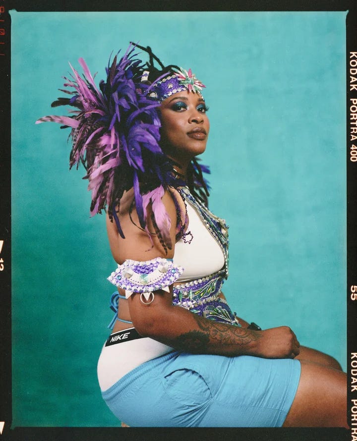 Portrait of Carnival attendee wearing purple feathers and armband