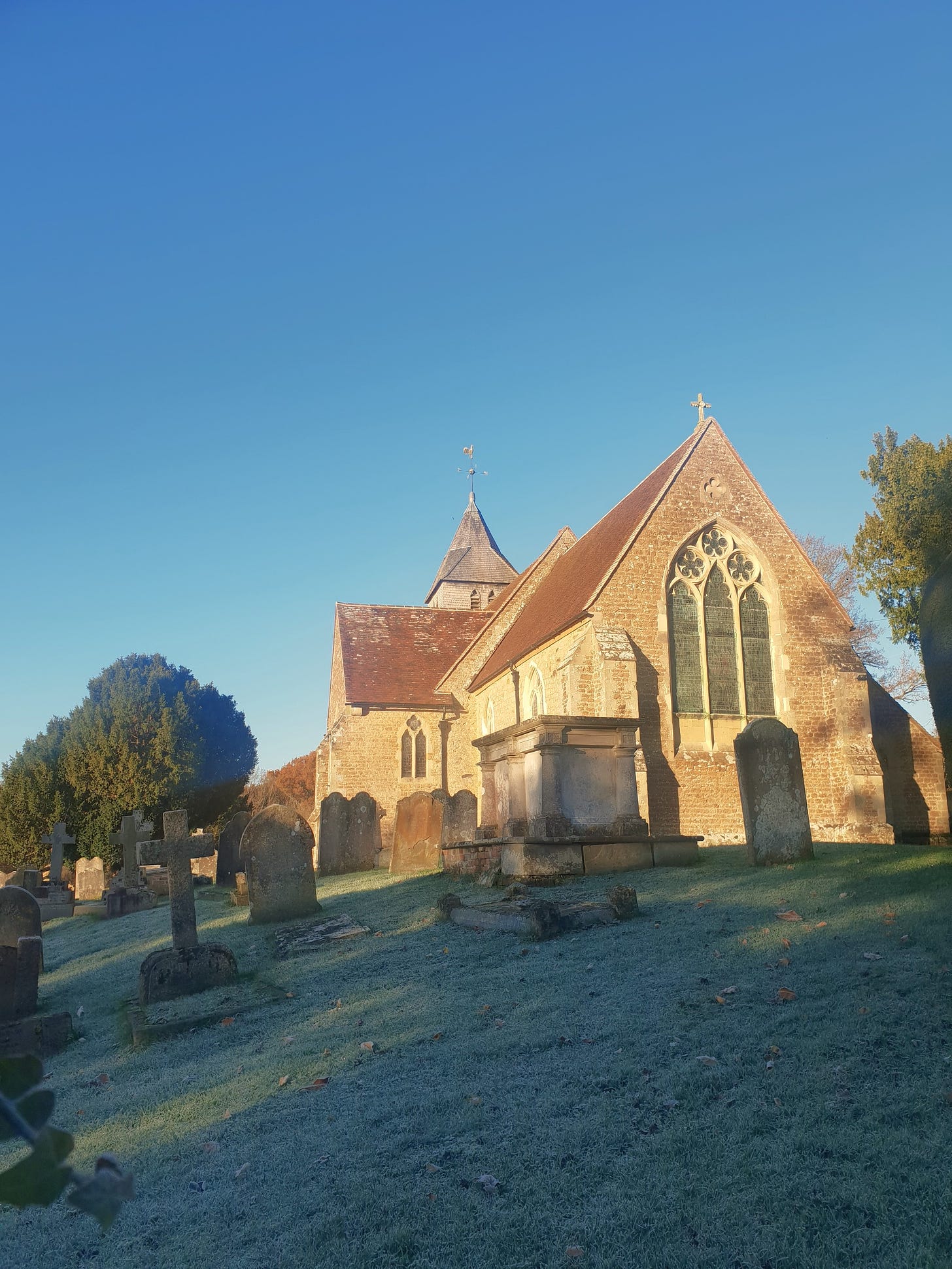 An English country church in a graveyard covered in frost