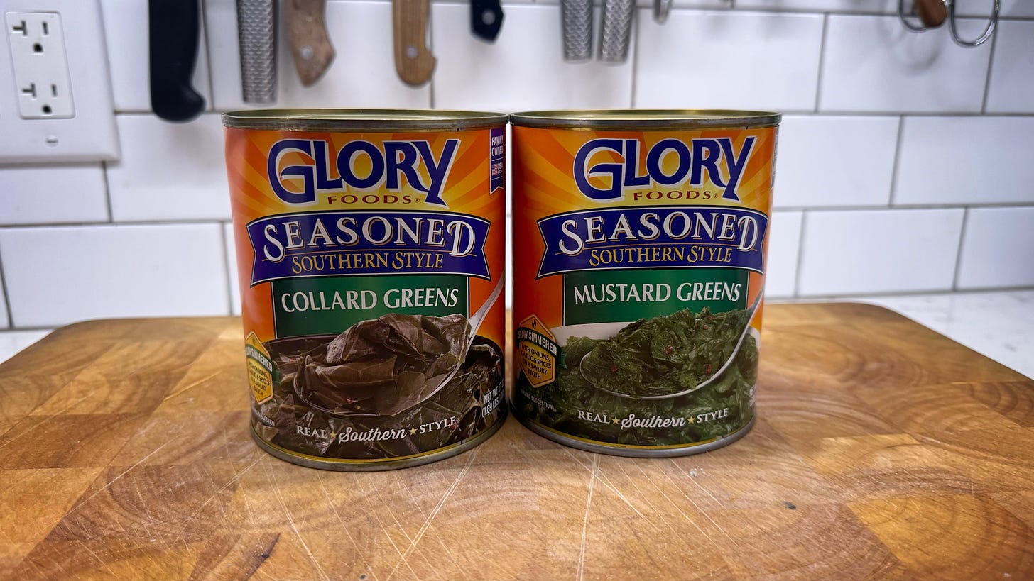 Two cans of Glory Foods Seasoned Southern Style Greens on a cutting board in my kitchen. One can is collard greens. The other is turnip greens.