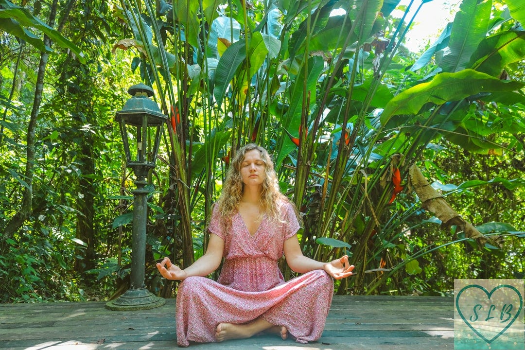 woman in pink dress sitting on wooden pathway