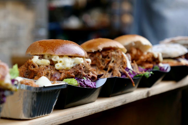 A row of burgers served on cardboard trays