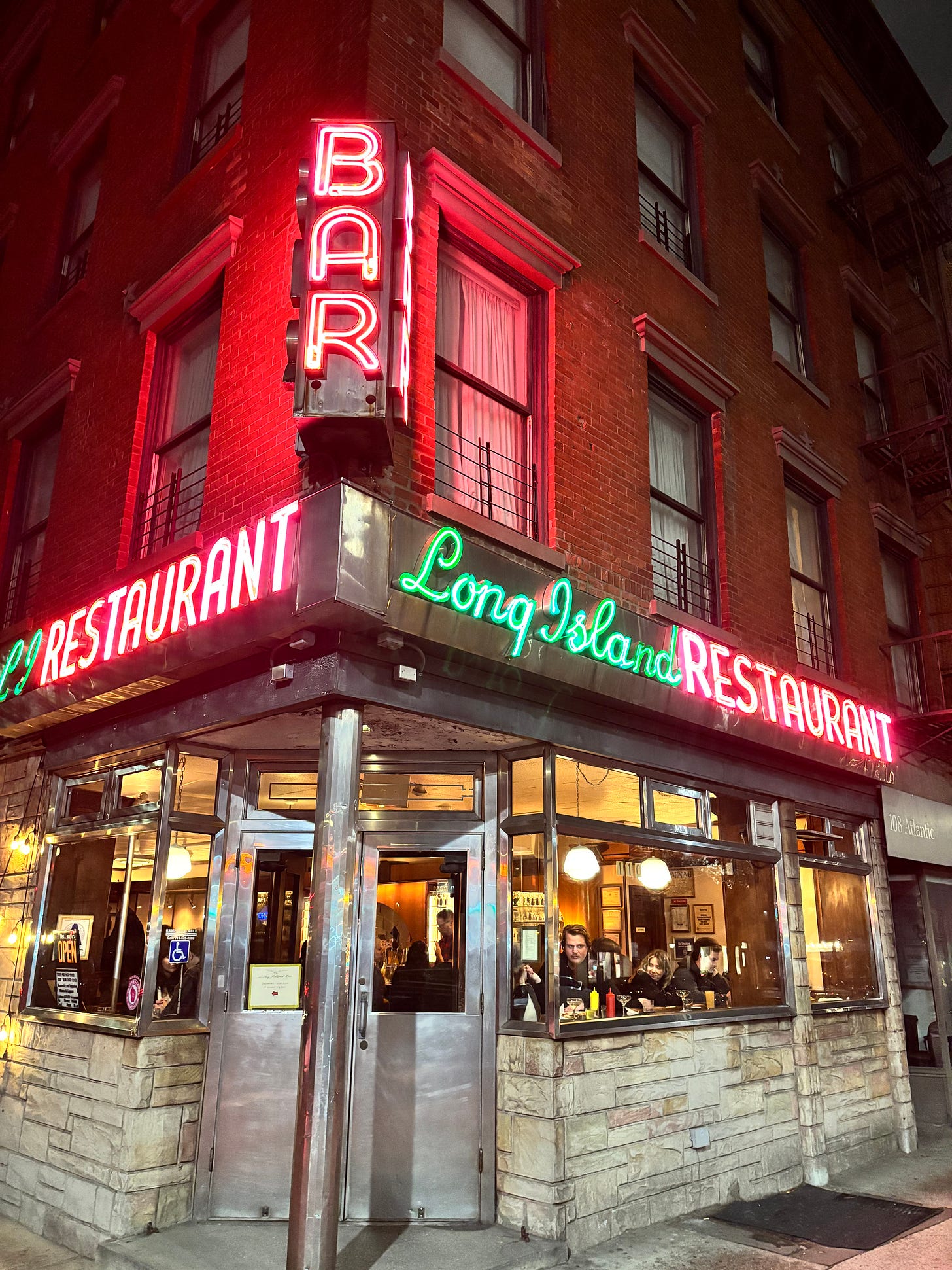 Neon sign reading "Long Island Restaurant" and "Bar" in red and green lettering.