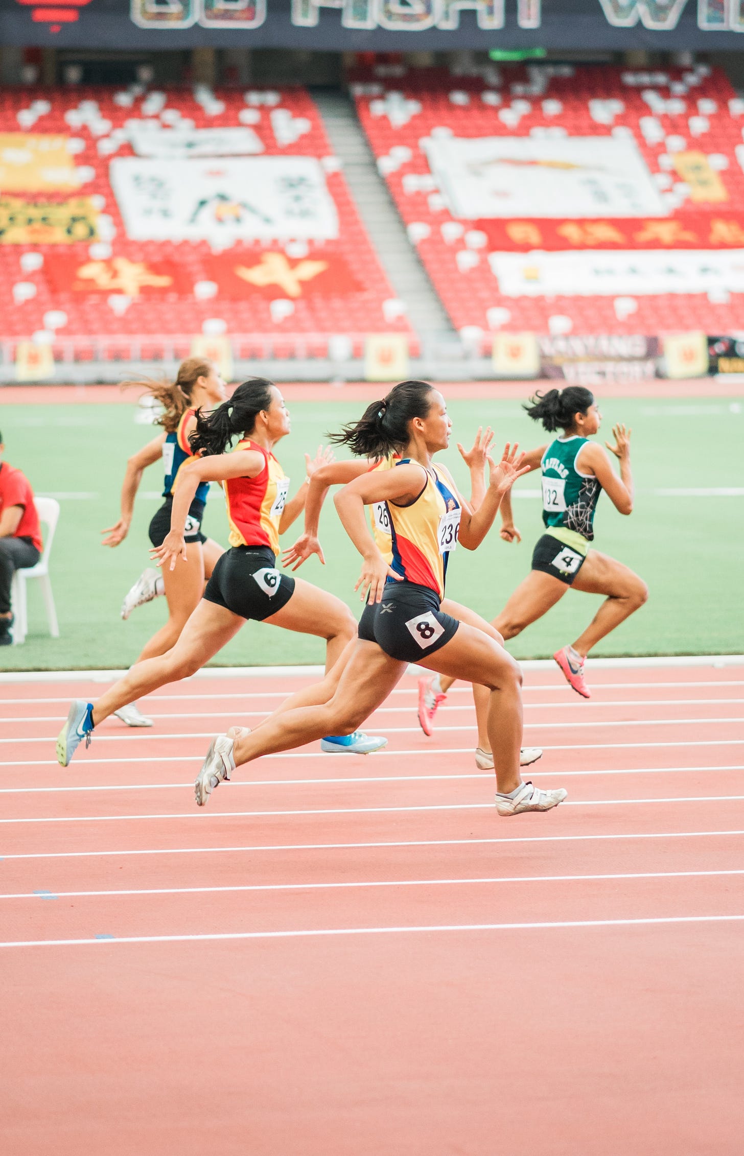 Female track athletes racing in a stadium