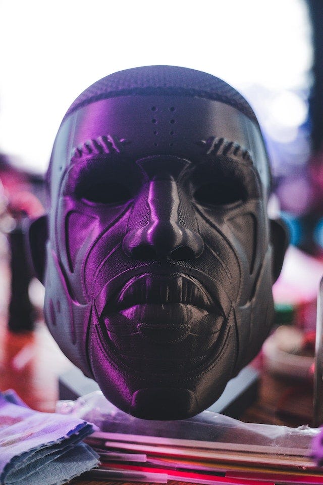 Close up photo of a black mask, with carved facial features