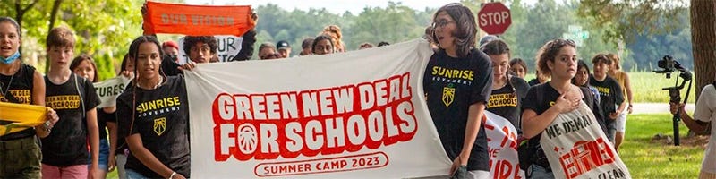 Students holding a banner that says "Green New Deal for Schools Summer Camp 2023"