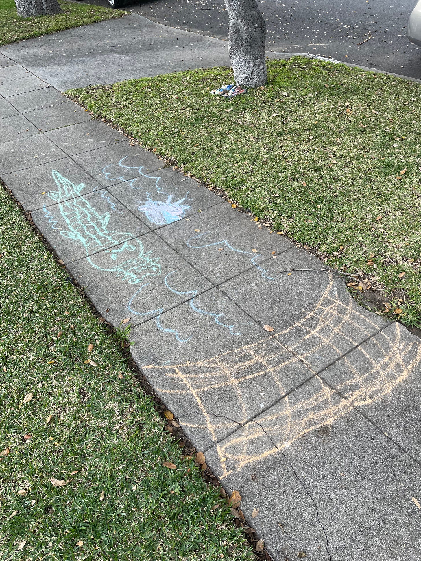 Sidewalk chalk portraying a bridge, river, and alligator