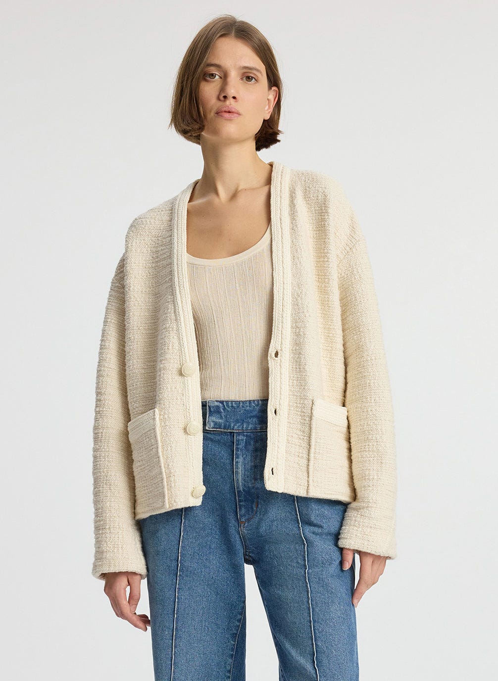 front view of woman wearing cream boucle jacket, cream tank top and medium blue denim jeans #1