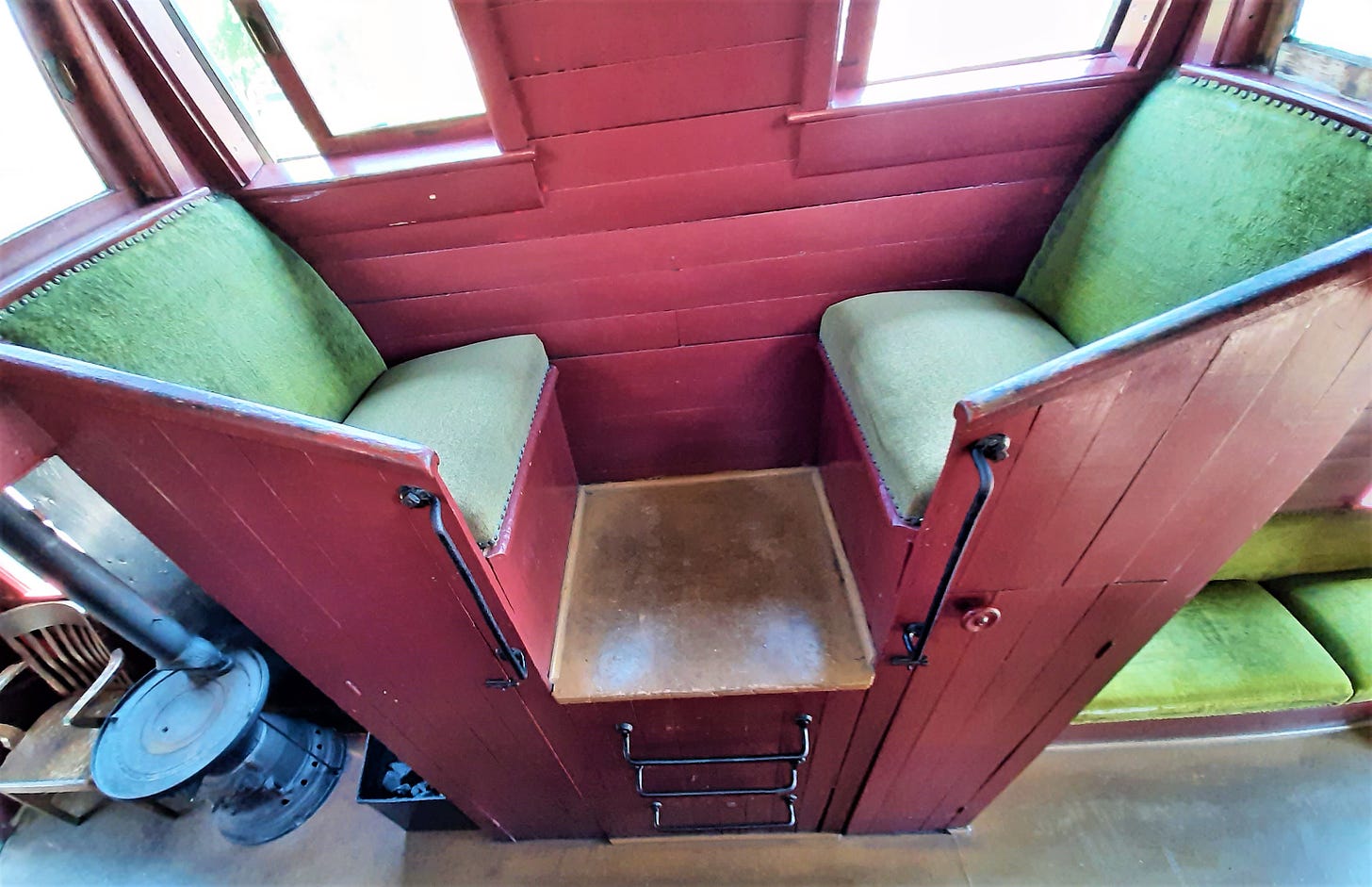 Two green velvet chairs in the caboose.