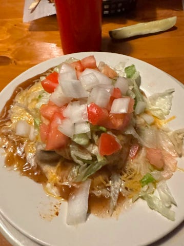 A wet burrito on a white plate