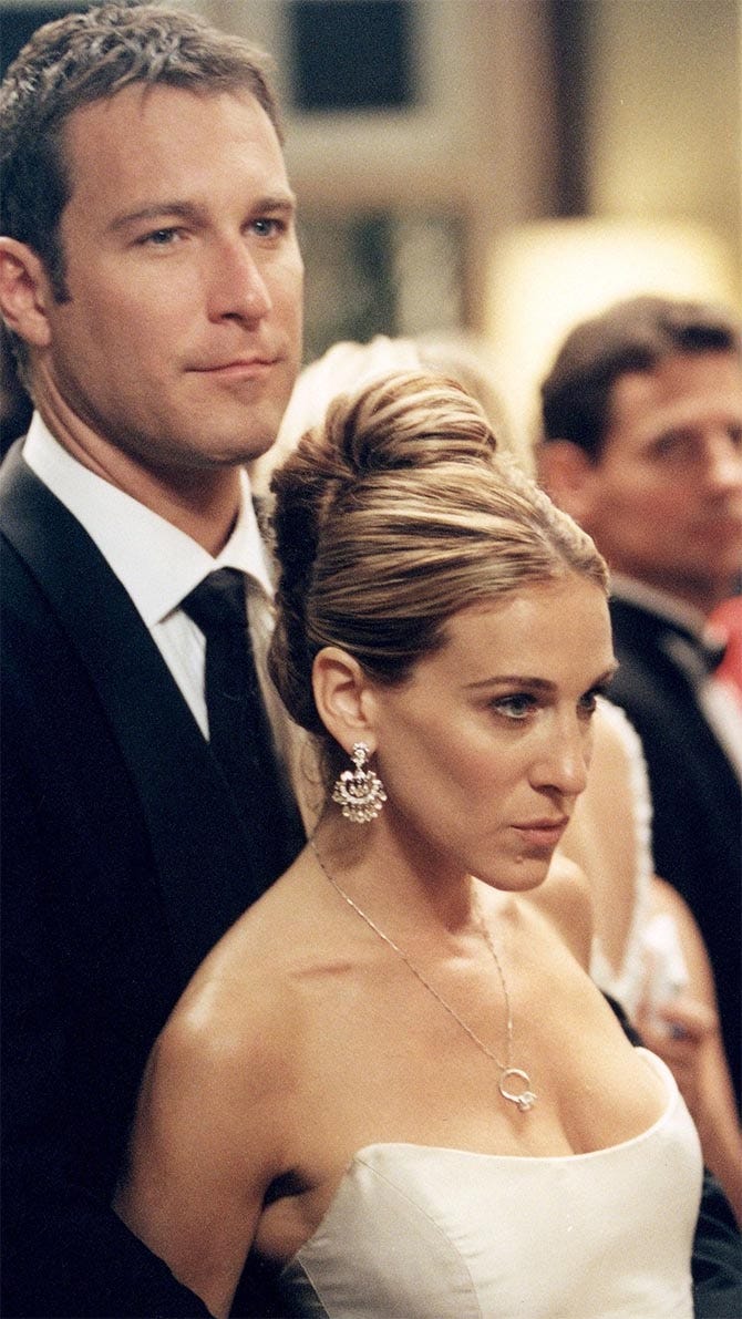 Jon Corbett with Sarah Jessica Parker who is wearing Fred Leighton Chandelier Earrings and Asscher Cut Diamond Engagement ring on a chain necklace