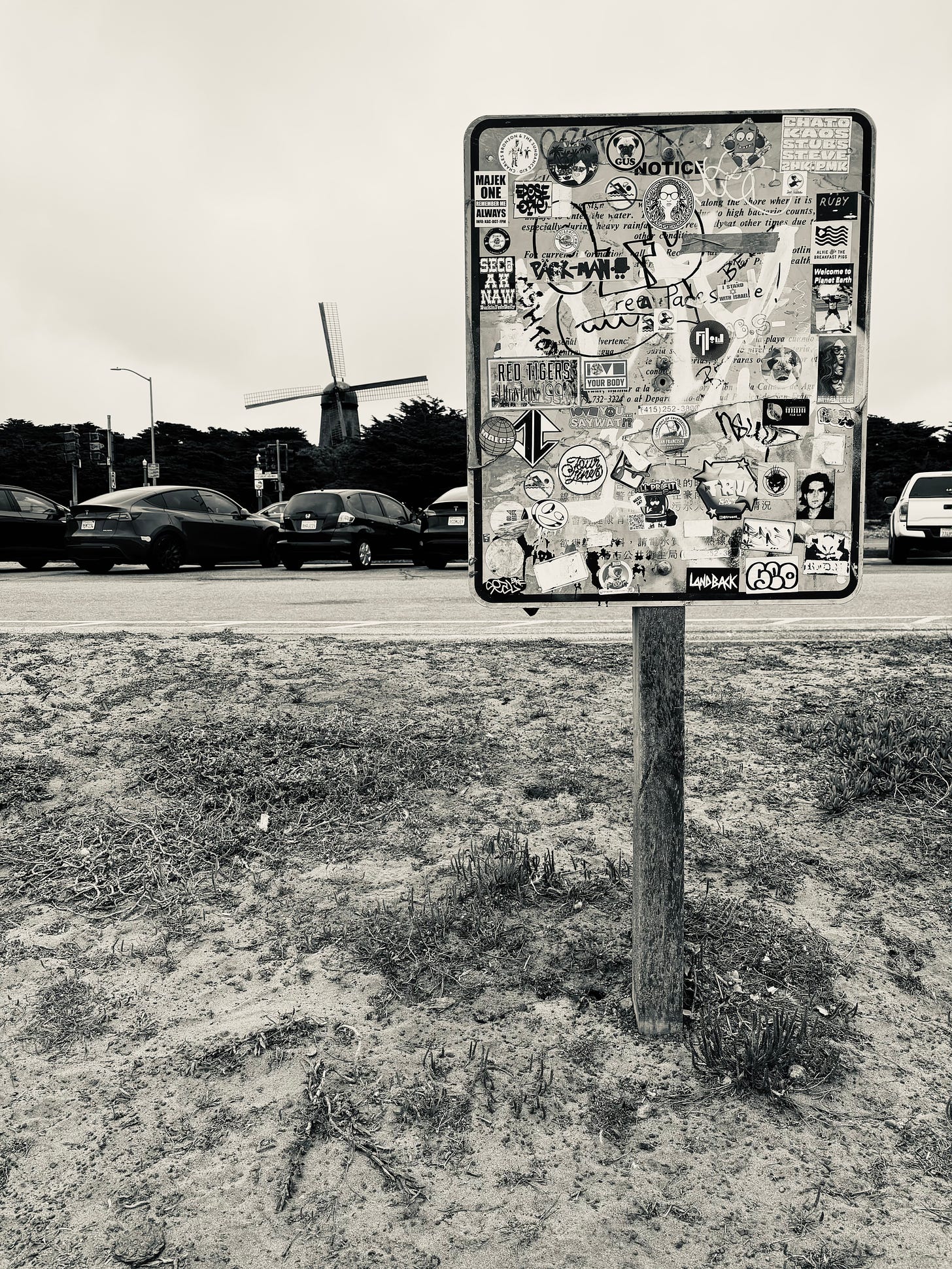 Sign covered in stickers at beach