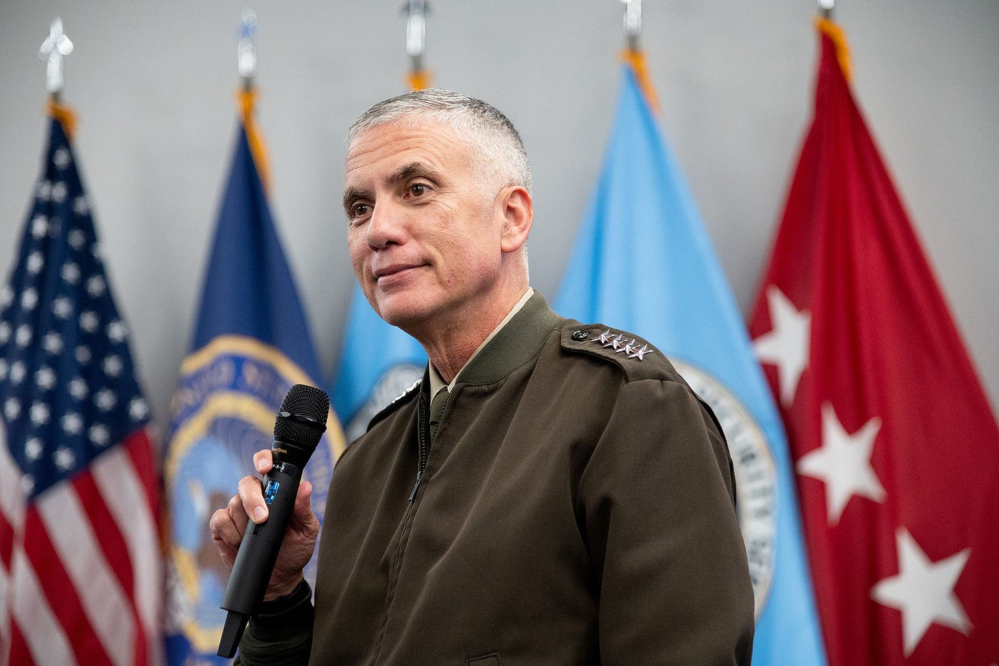 A photo of General Paul Nakasone with a microphone in hand.