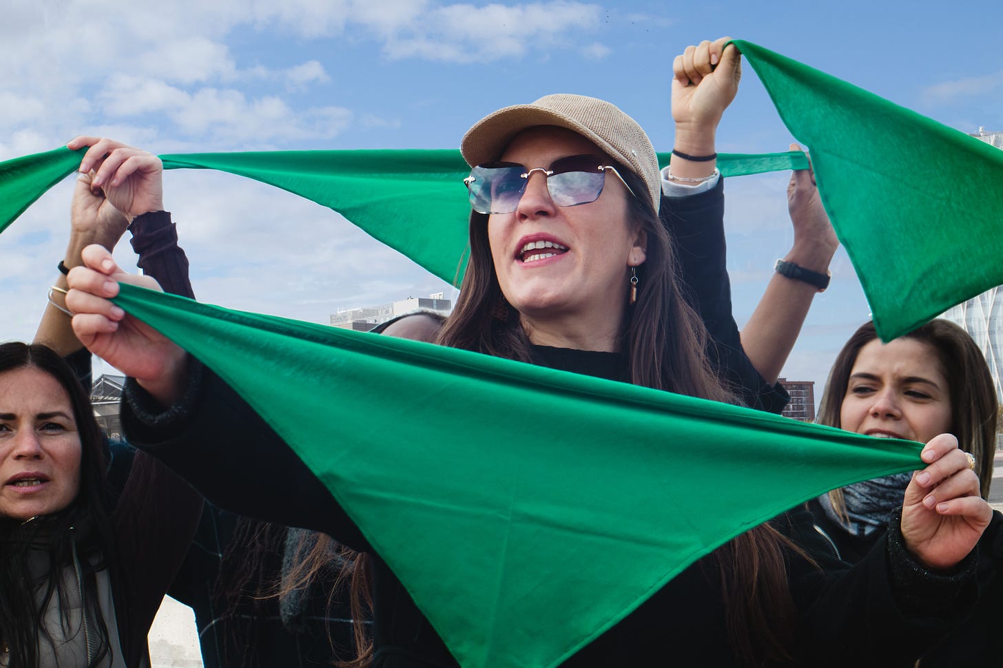Woman standing with folded green bandanas in hand