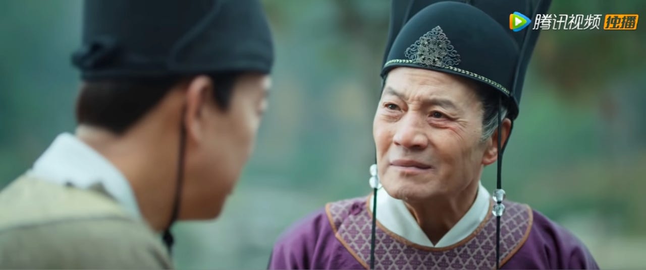 An older Chinese eunuch conversing with a younger eunuch