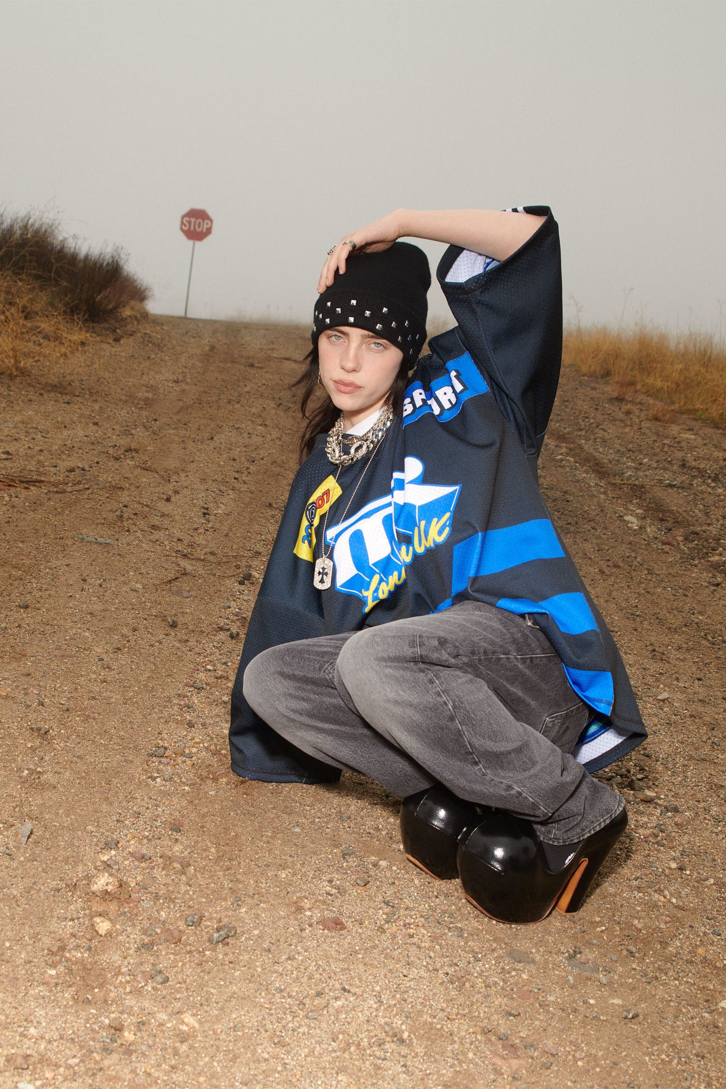 Image may contain Billie Eilish Soil Photography Face Head Person Portrait Clothing Pants Helmet and Footwear