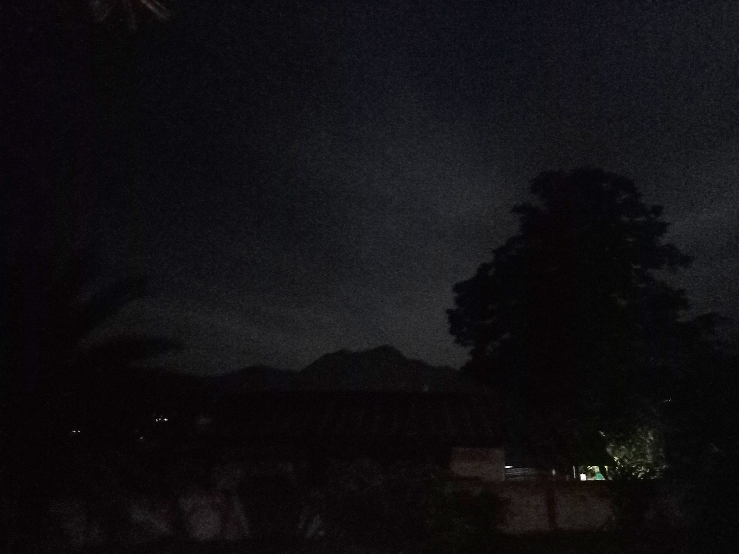 a photo in the night with the mountain range illuminated from behind with the light of the full moon