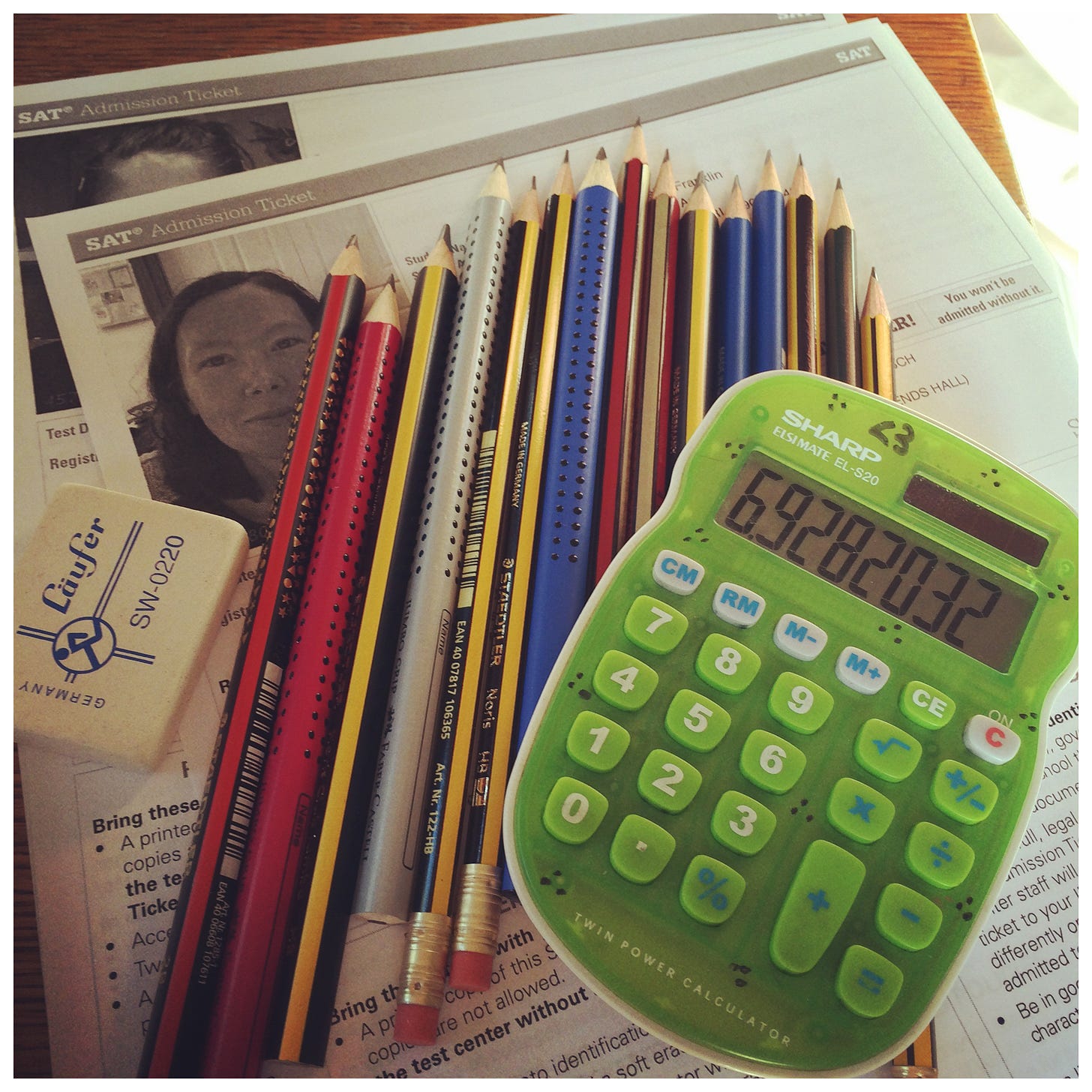 Photo of a green kid's calculator and a bunch of sharpened pencils.