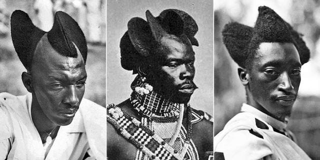 Three Rwandan men with their hair shaped into swooping, curved figures