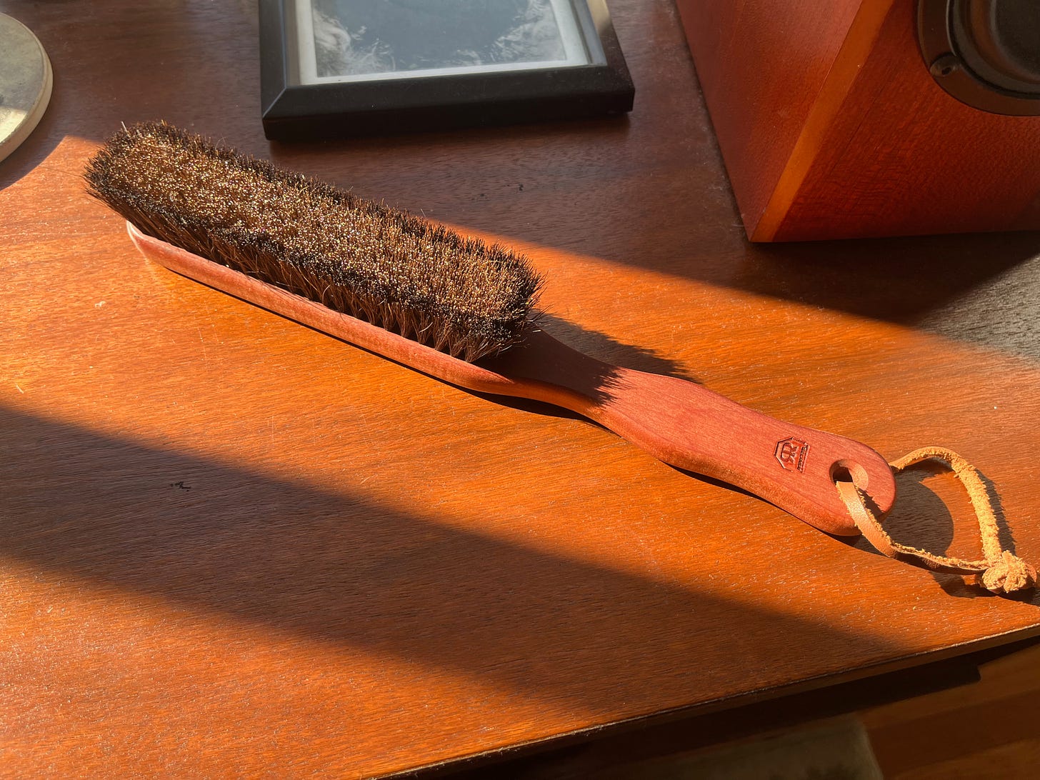 an absolute beauty of a wood-handled garment brush basking in the afternoon sunlight