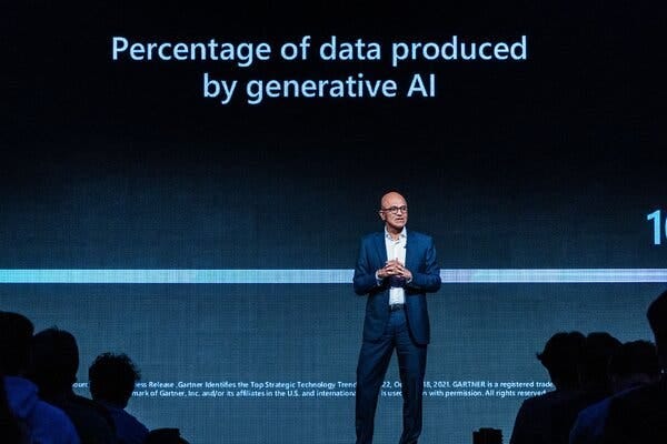 Satya Nadella standing on a stage, with the words ‘Percentage of data produced by generative AI’ displayed behind him.  