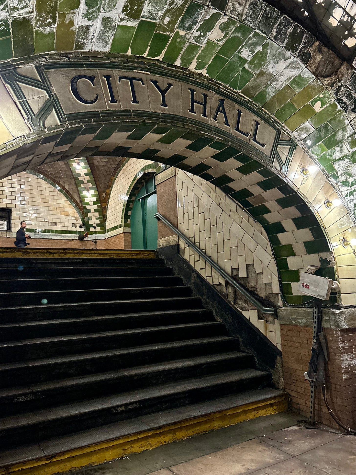 A green-tiled arch labeled City Hall over that same stairway.