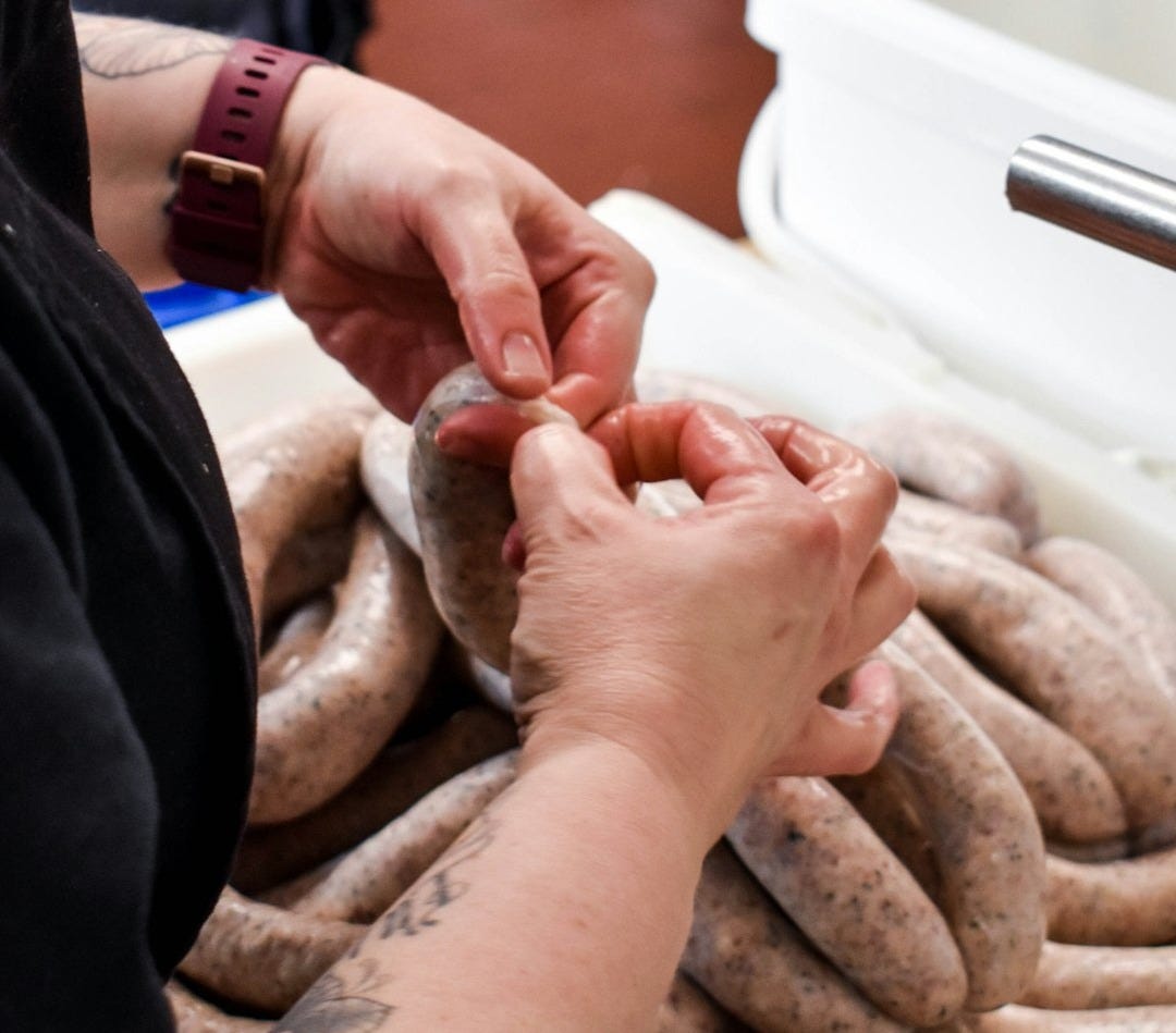 a person holding a sausage in their hands