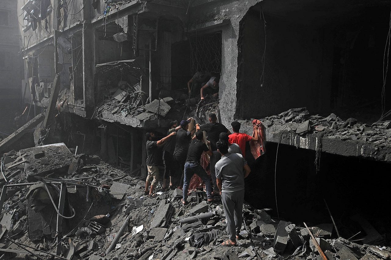 Παλαιστίνιοι προσπαθούν να σώσουν επιζώντες και να βγάλουν πτώματα από τα ερείπια μετά από ισραηλινές αεροπορικές επιδρομές σε κτίρια κοντά στο Νοσοκομείο Μαρτύρων Al-Aqsa στο Deir al-Balah, κεντρική Γάζα, 22 Οκτωβρίου 2023. (Mohammed Zaanoun)