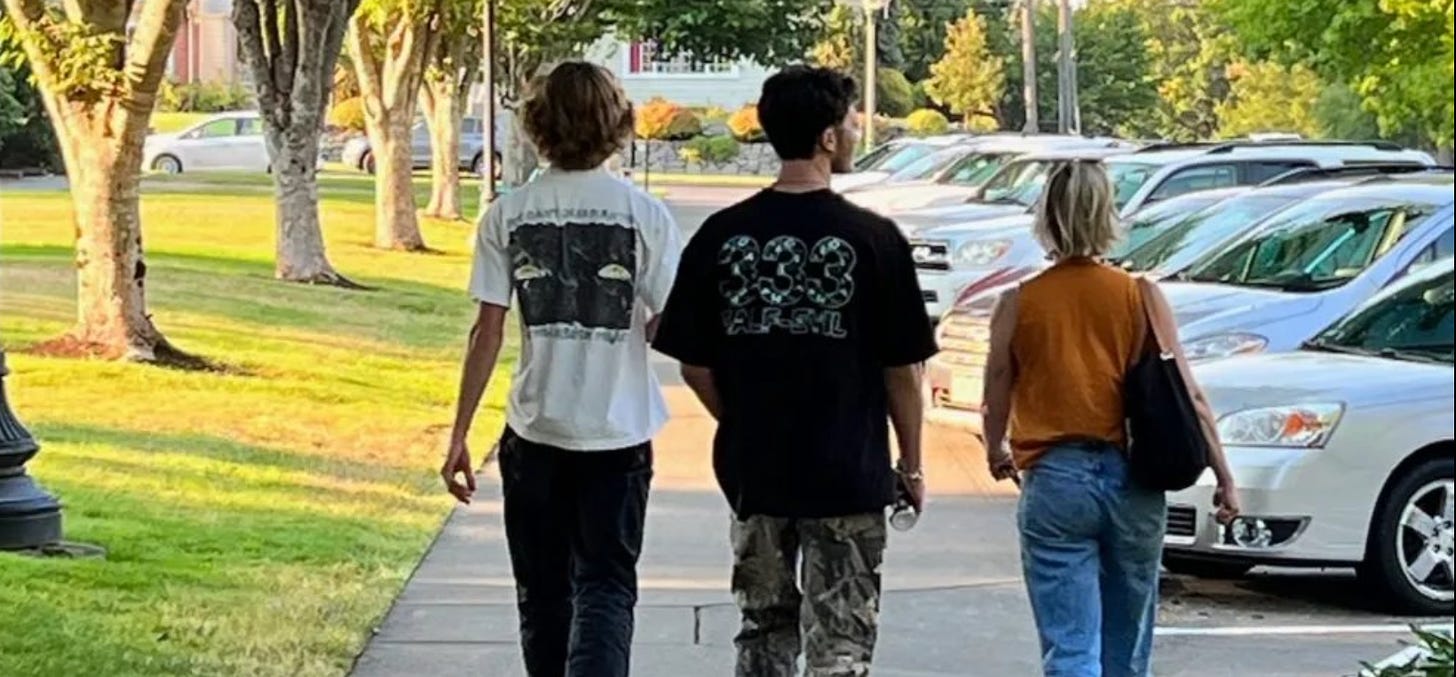 The author with her sons, walking down a sidewalk, view from behind